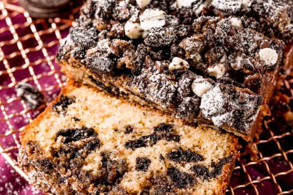 Slices of Oreo crumb loaf cake on a cooling rack.