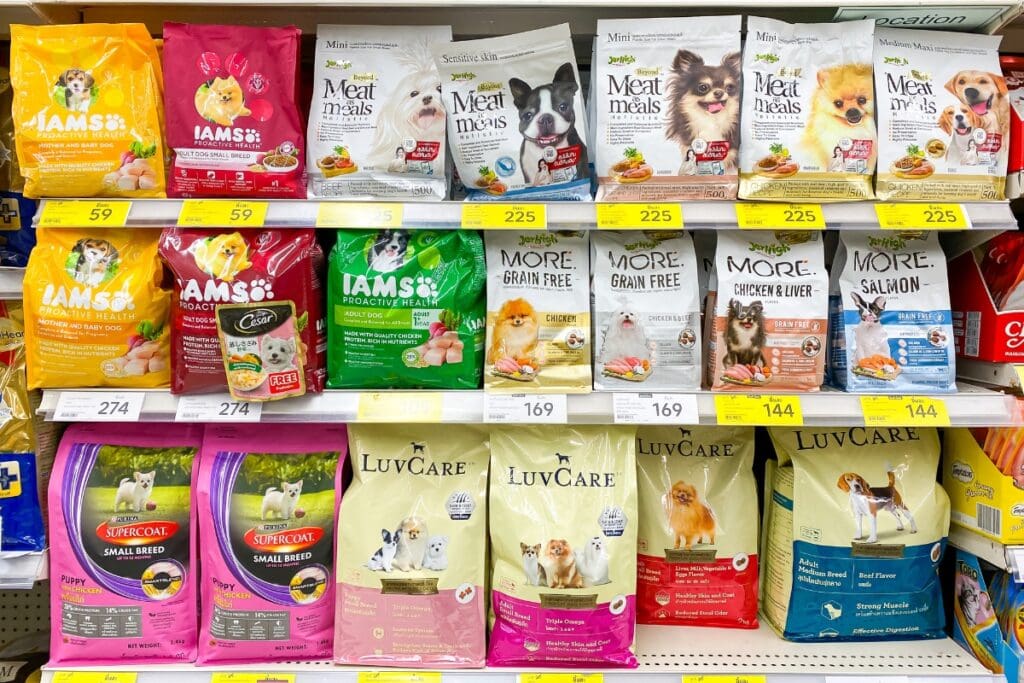 Bags of pet food displayed on a store shelf.