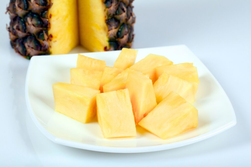Sliced pineapple on a white plate.