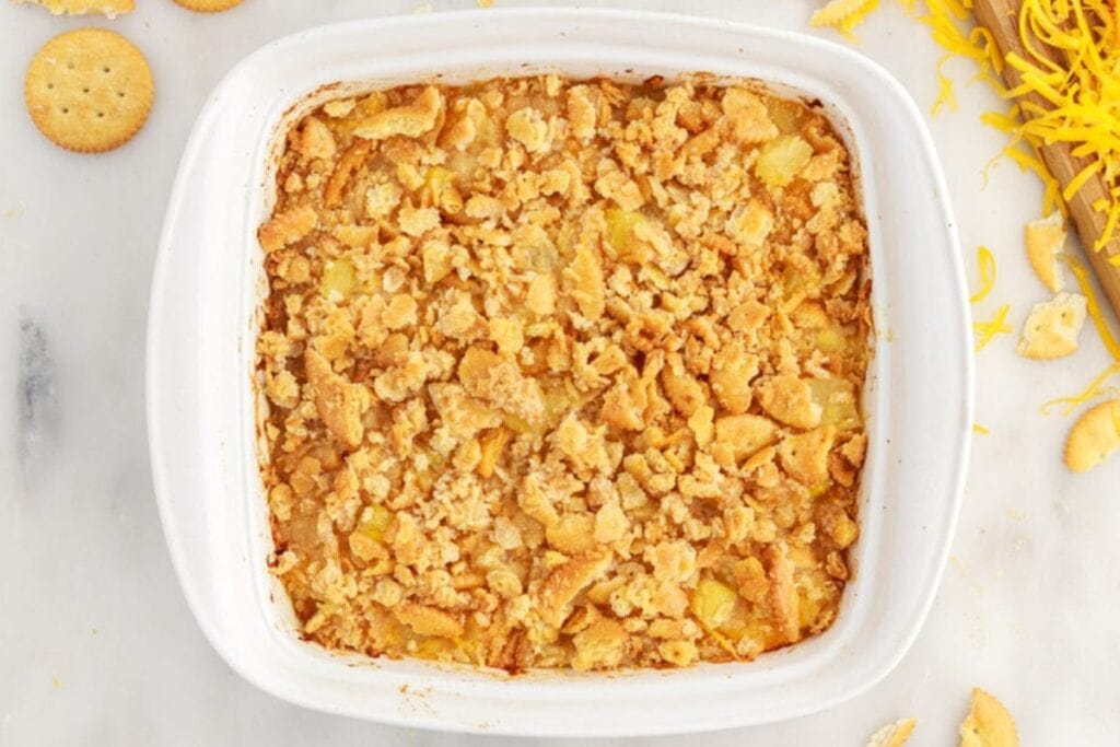 Pineapple casserole baked in a white square baking dish.