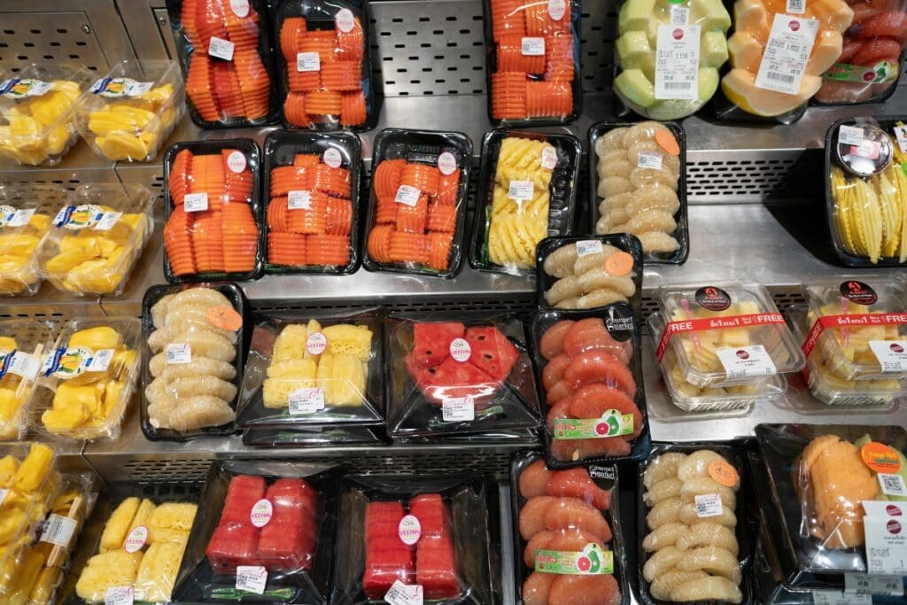 Pre-cut fruits and vegetables displayed on a store shelf.