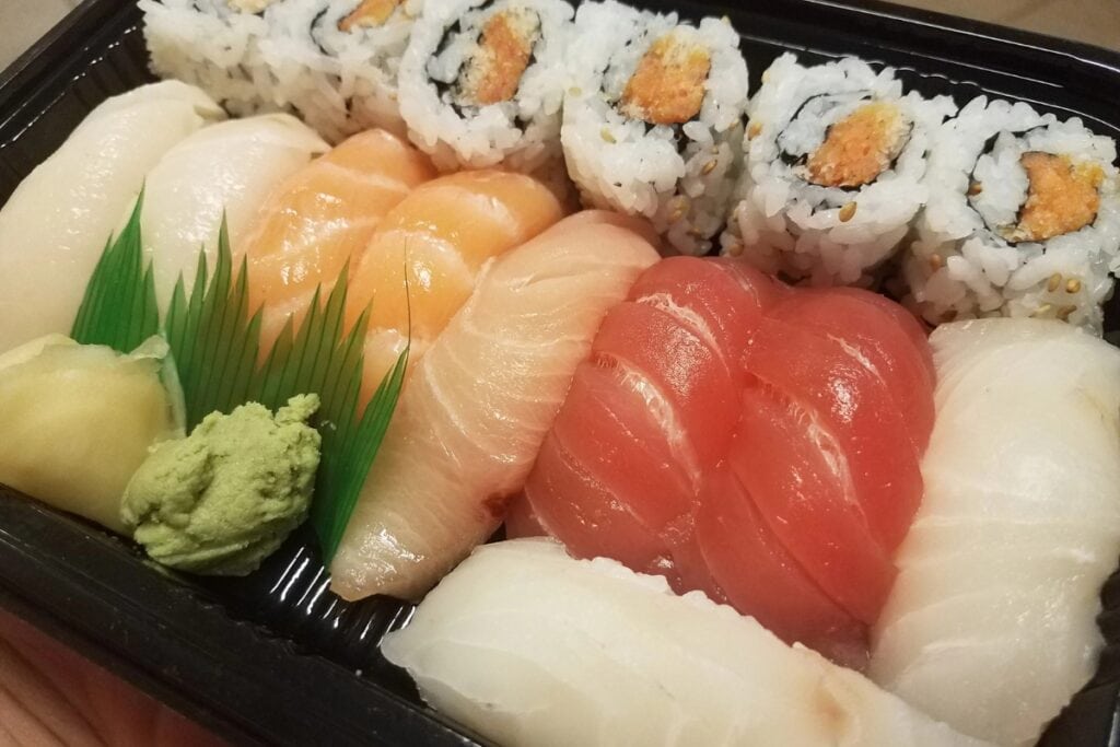 Ready-made sushi in a black plastic container.