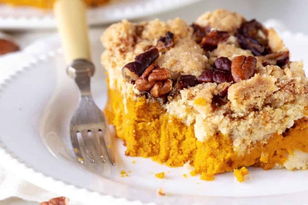 Pumpkin Dump Cake on a dessert plate with fork on the side.