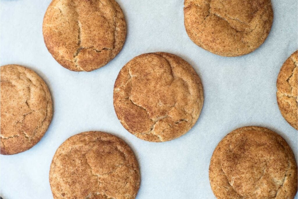 Pumpkin spice snickerdoodles on a parchment paper.