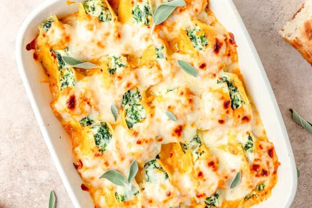 Pumpkin stuffed shells in a white rectangular baking dish.