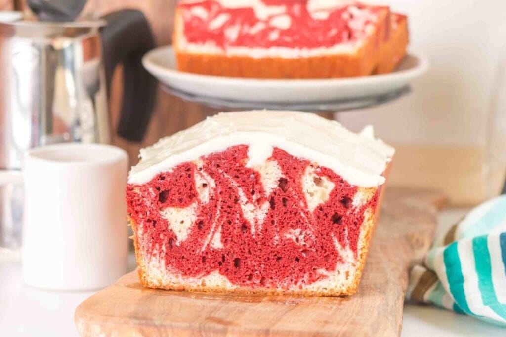 Red velvet marble loaf cake on a wooden board.