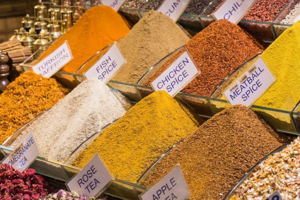 Assorted loose spices on display at an international market.