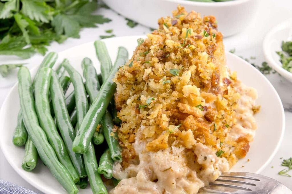 Slow cooker chicken and stuffing served with green beans on a plate.