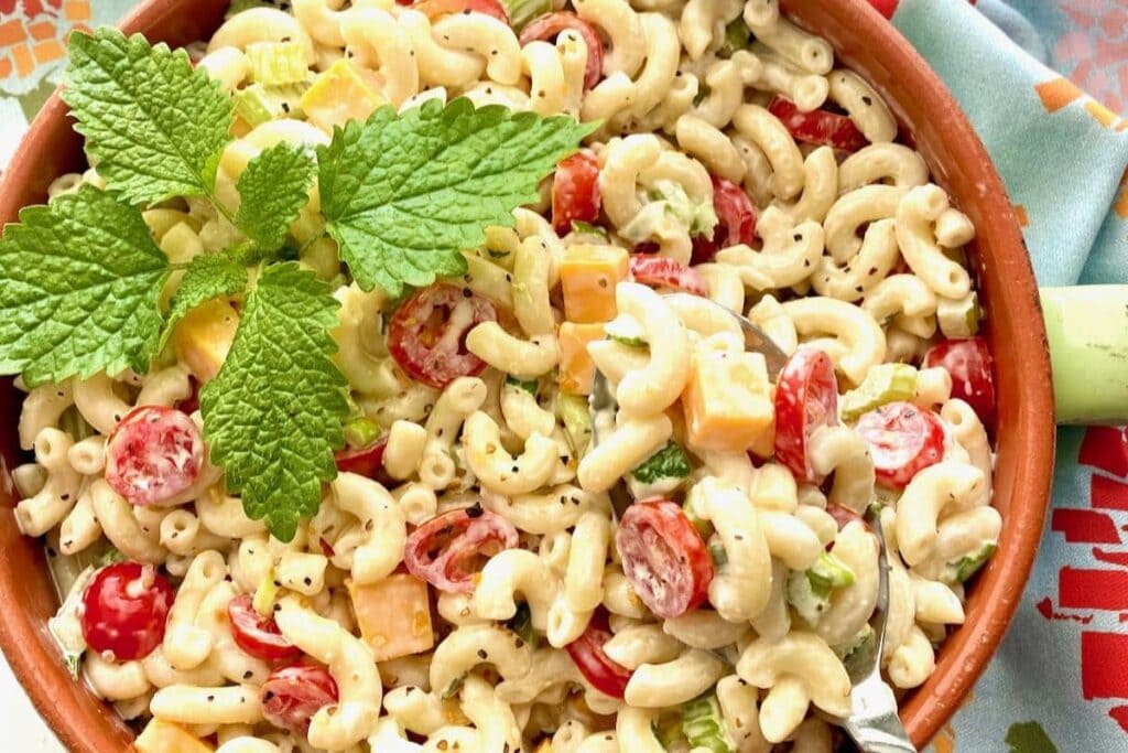 Southern macaroni salad in a bowl topped with mint leaves.