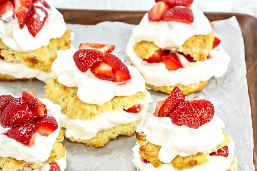 Strawberry shortcakes on a wooden tray.