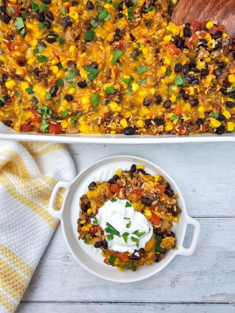 Delicious Mexican casserole with ground beef, corn, black beans, and melted cheese.