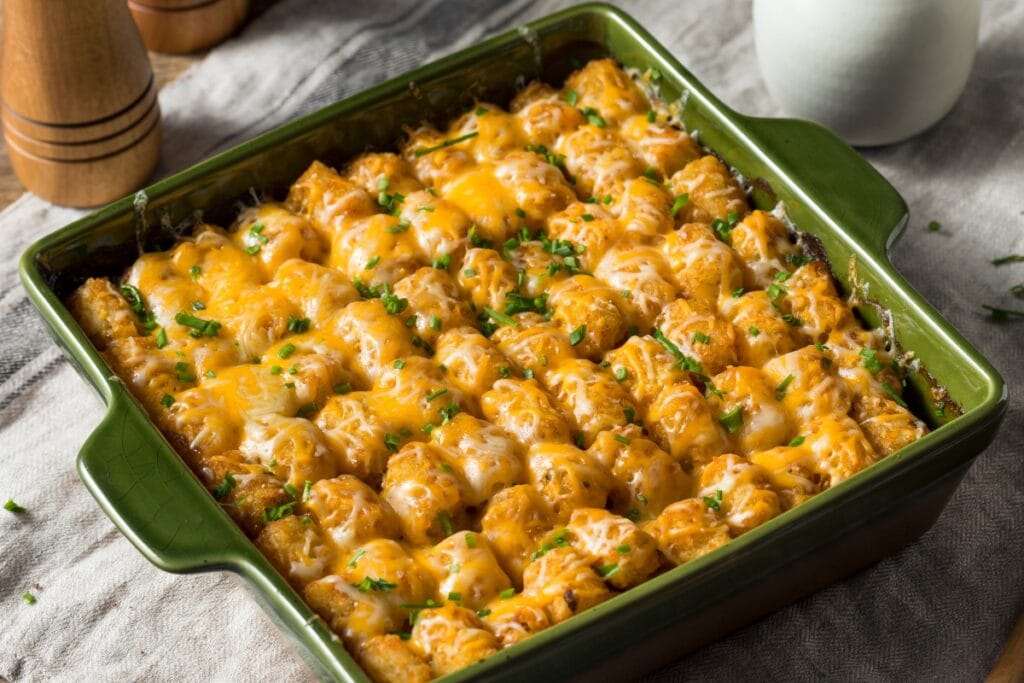 Tatertot casserole in a square green baking dish.
