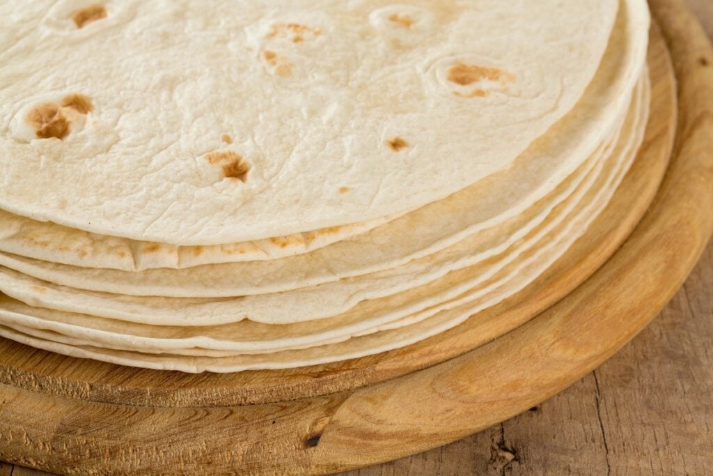 Tortillas on a wooden circular board.