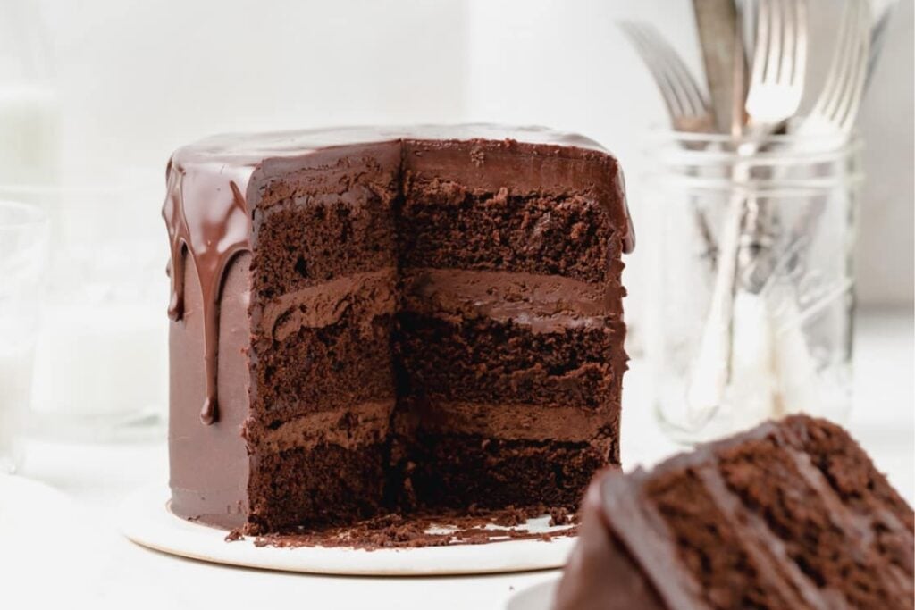 Triple chocolate layer cake with one slice out.