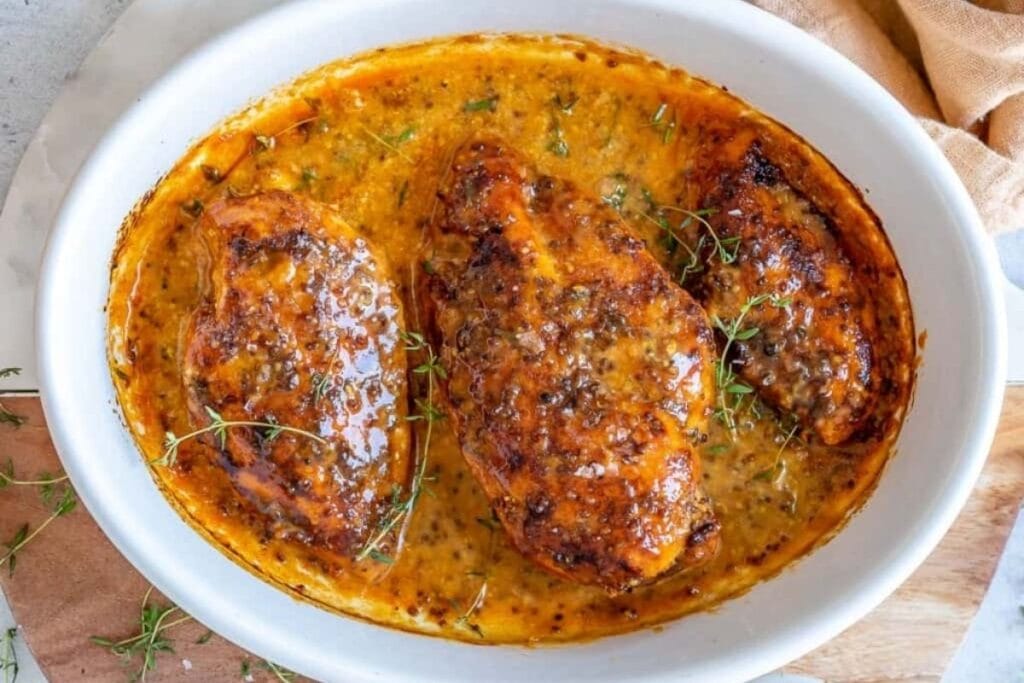 A close up shot of baked honey mustard chicken.