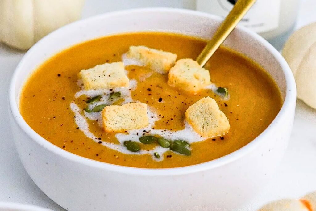 Creamy pumpkin soup with croutons and pumpkin seeds for a healthy, comforting meal. Savvy Honey recipe for fall comfort food.