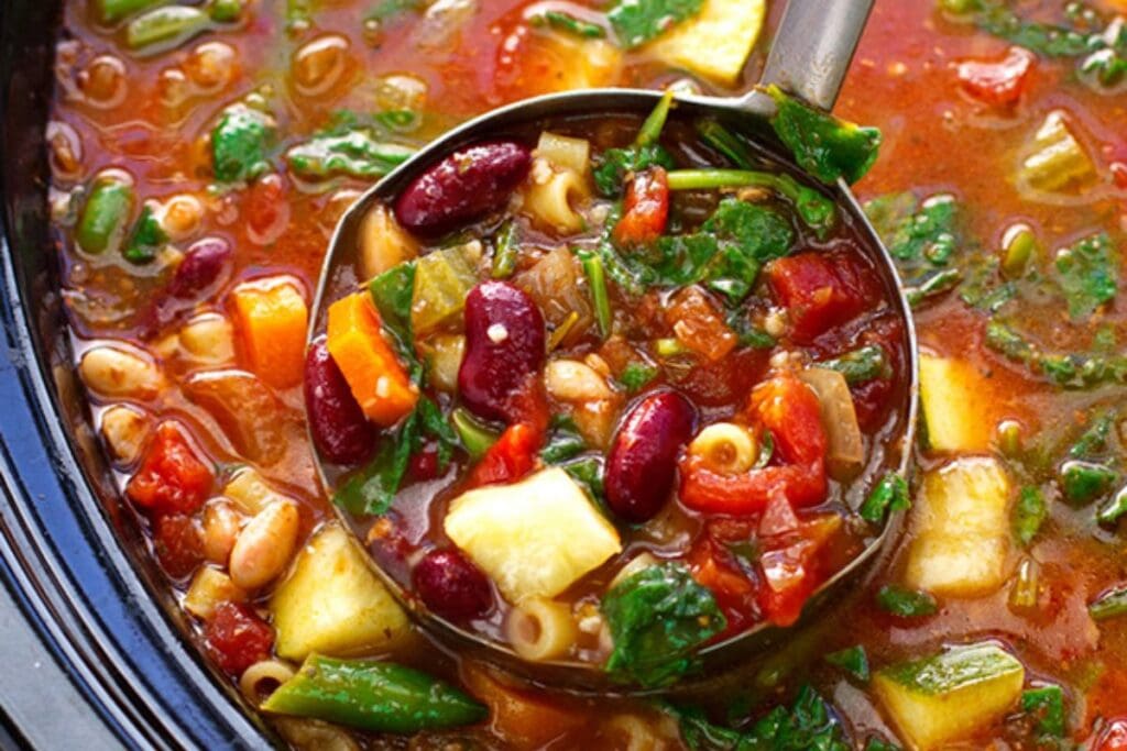Vegetable soup with beans, corn, and mixed vegetables, in a slow cooker.