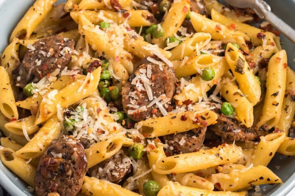 A close up shot of sausage penne peas.