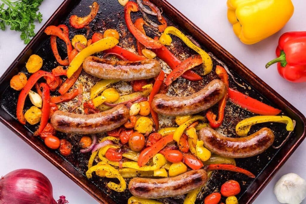 Sausage and peppers on a a sheet pan.