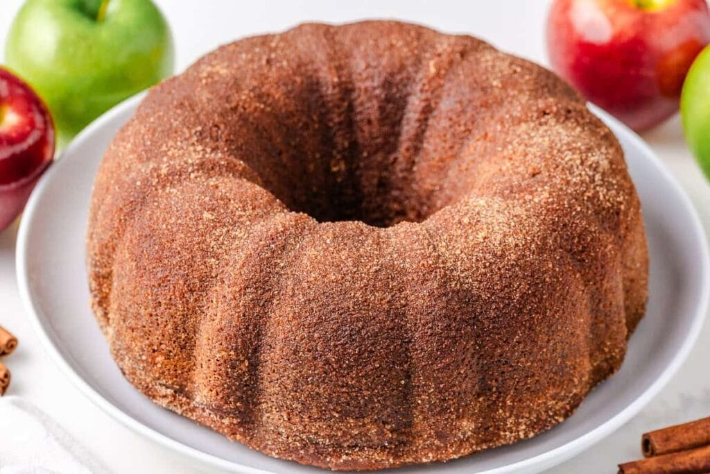 Whole apple cider donut cake on a plate.