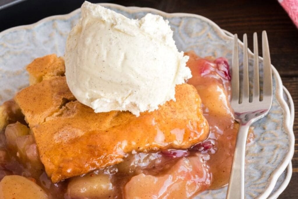 Apple cranberry crisp on a plate with a fork on the side.