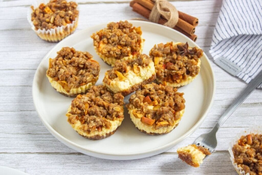 Apple crisp mini cheesecakes on a plate.
