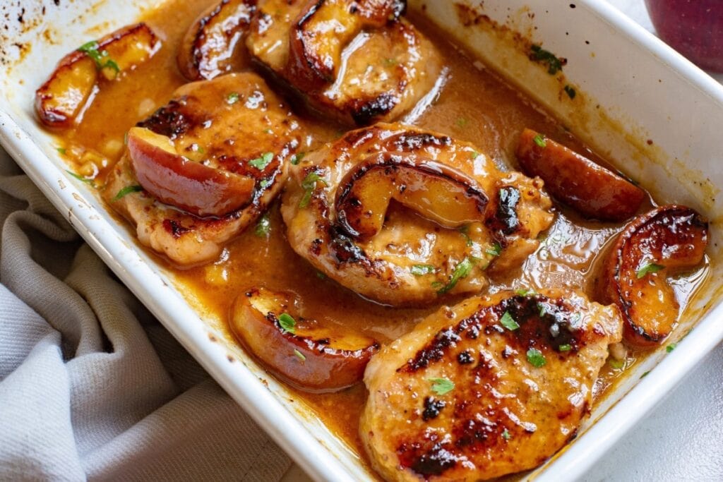Apple pork chops in a baking dish.