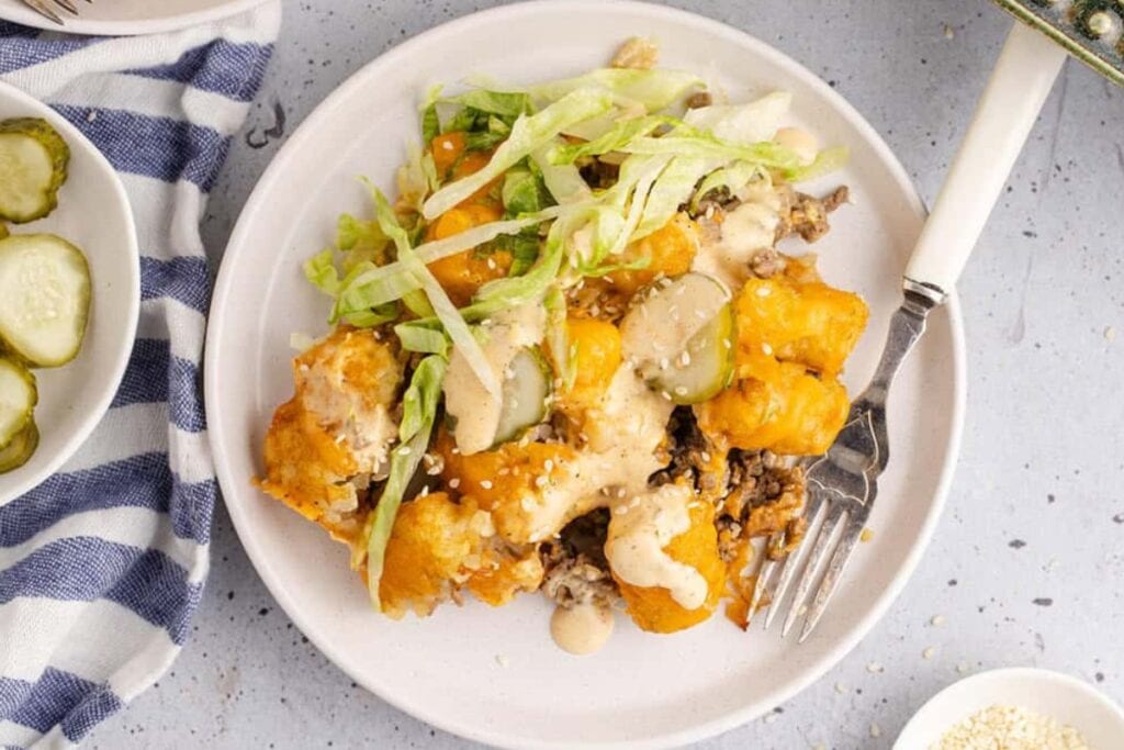 Big Mac tater tot casserole on a plate with a fork on the side.