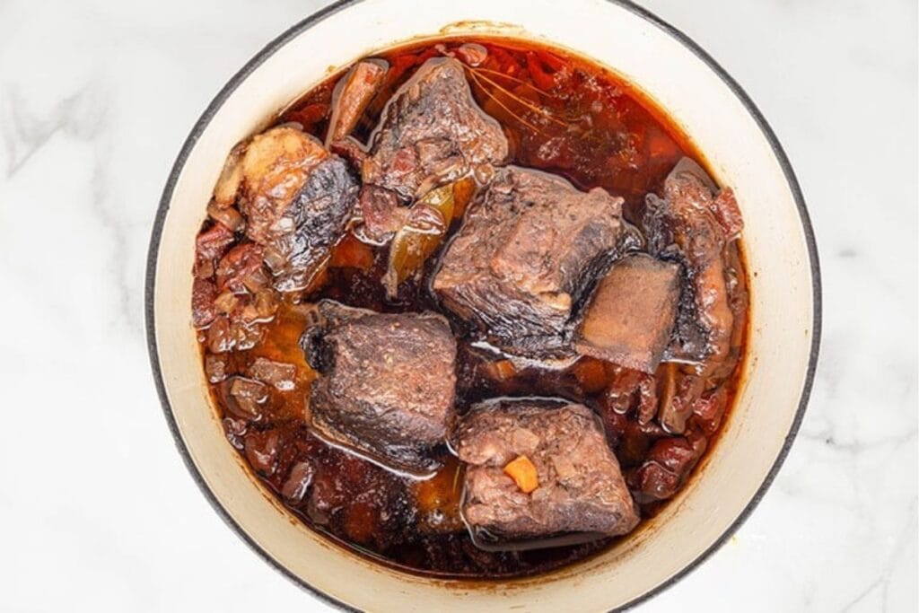Braised beef short ribs in a pot.