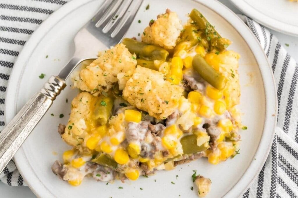 Cheesy Hamburger Tater Tot Casserole served on a plate with a fork on the side.