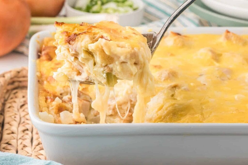 Chicken cordon bleu casserole in a baking dish scooped with a serving spoon.