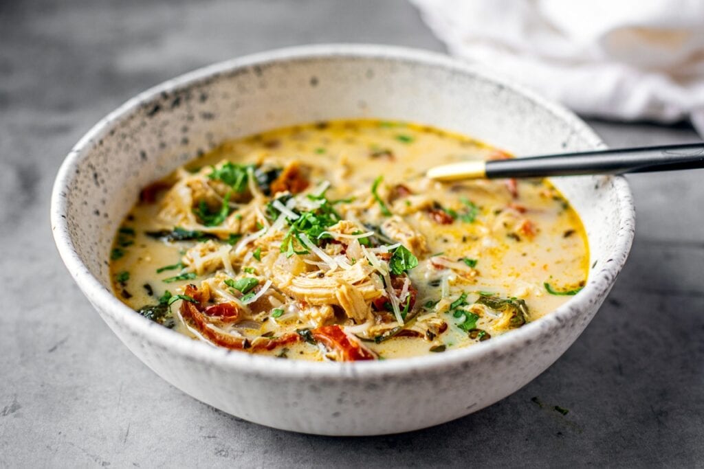 Chicken Florentine soup in a white bowl.