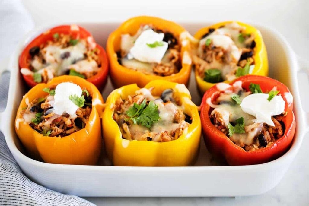 Chicken stuffed peppers in a rectangular baking dish.