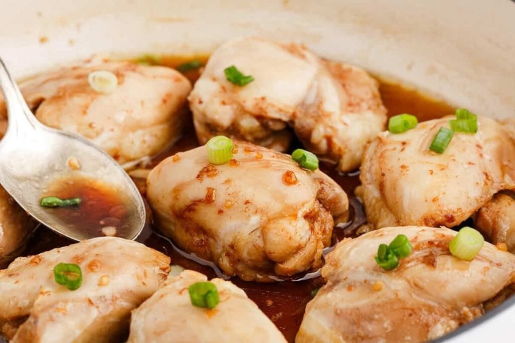 Chicken thighs with honey in a skillet.