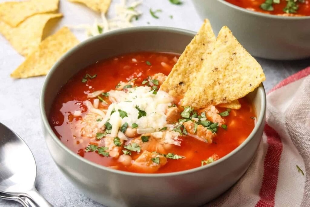 Bowl of chipotle chicken soup with tortilla chips.
