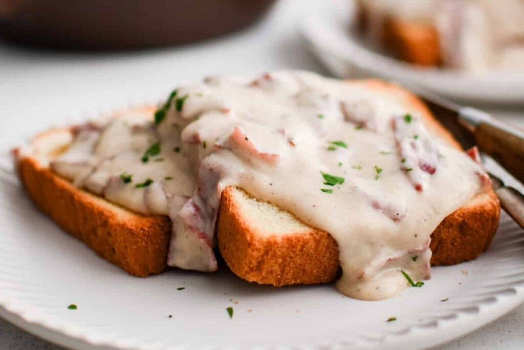 Chipped beef on toast on a white plate.