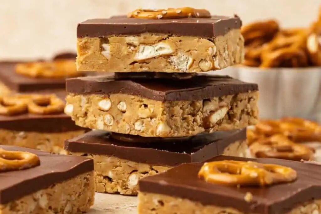 Chocolate peanut butter pretzel bars stacked on a plate.