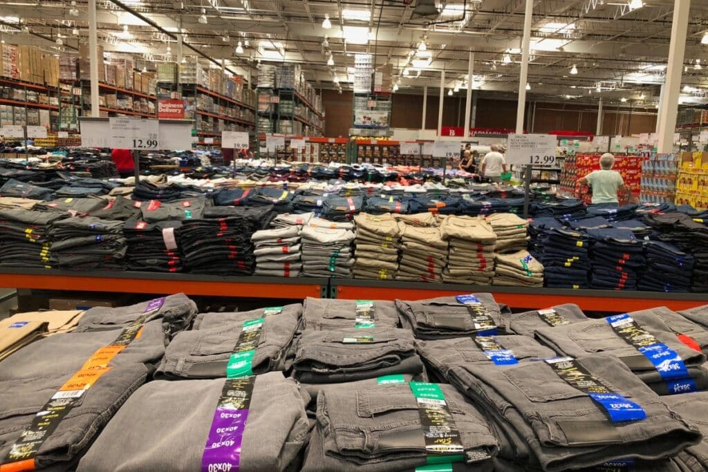 Clothing items displayed on tables and racks in a store.