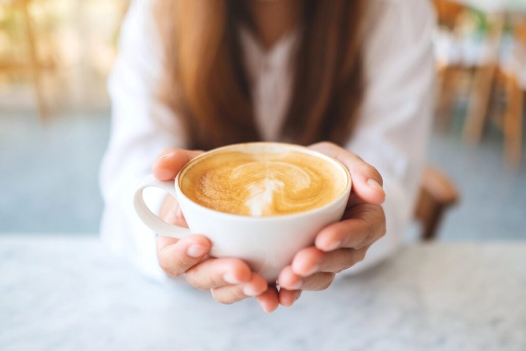 Woman holding a cup of coffee.