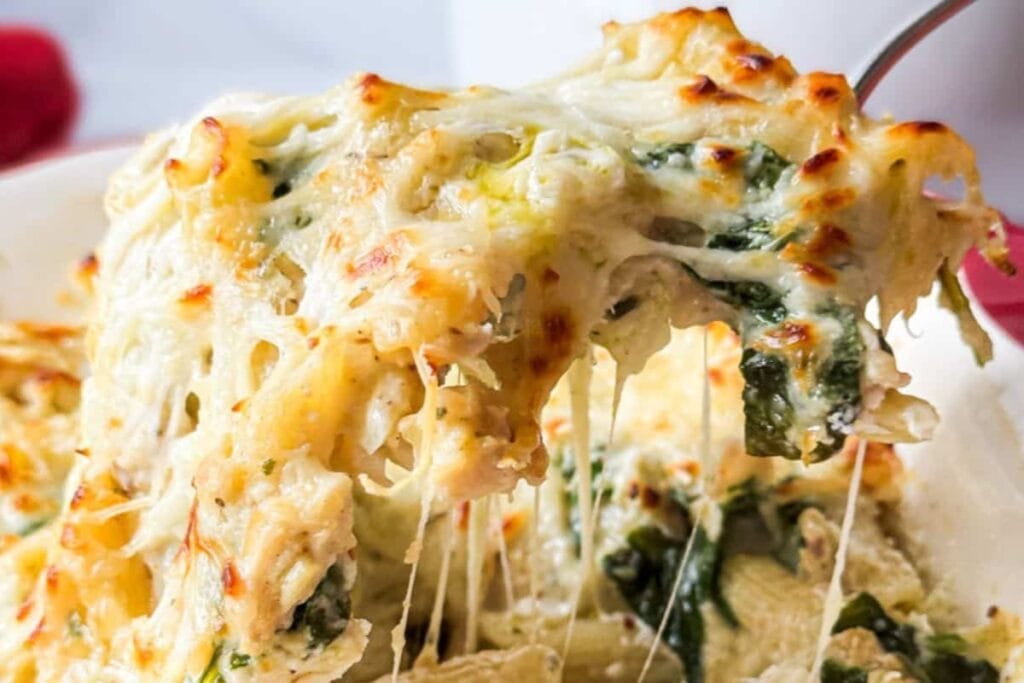 Creamy chicken alfredo casserole on a spoon.