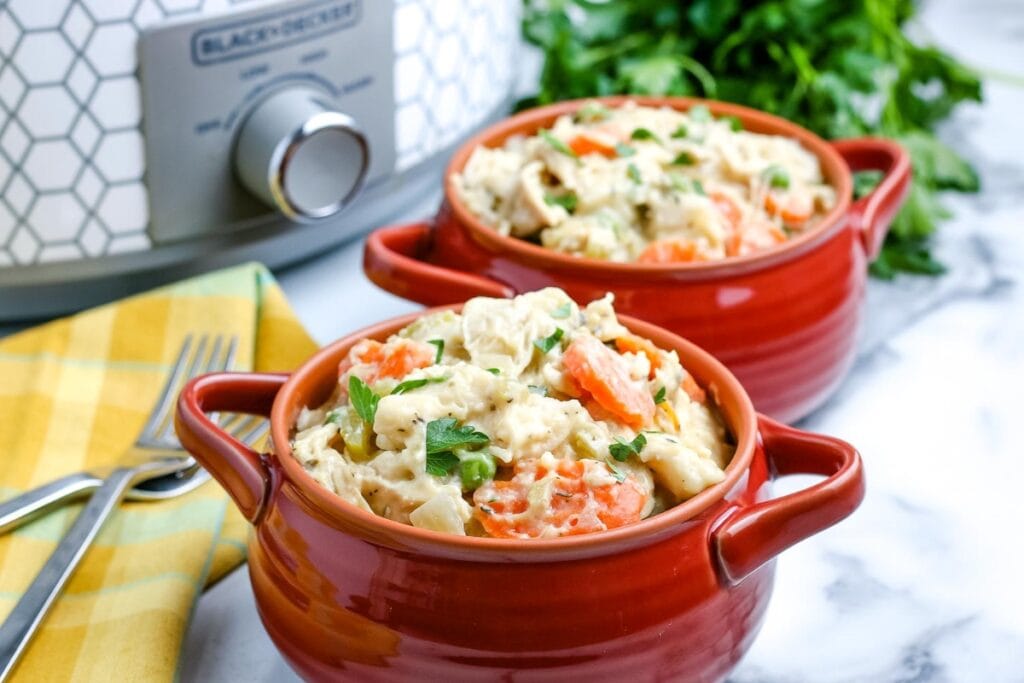 Crockpot chicken and dumplings served in a handled soup bowl.