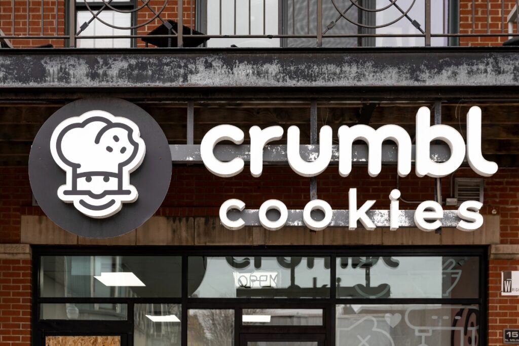 Crumbl Cookies store with glass walls and a white logo sign.