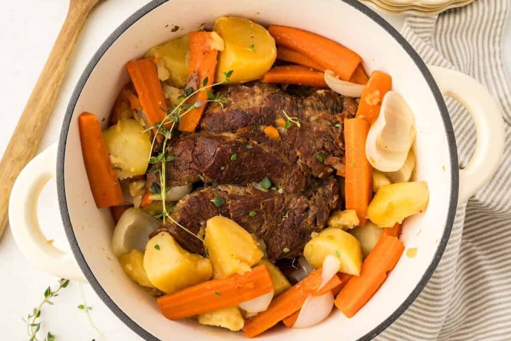 Dutch oven pot roast with vegetables in a pot.