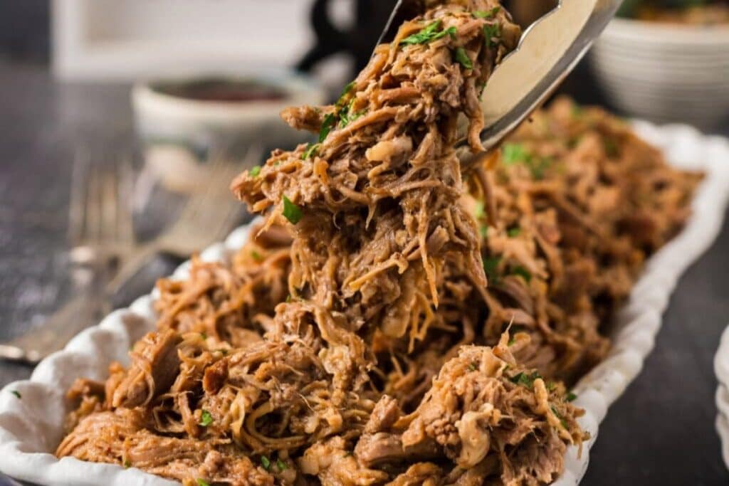 Dutch oven pulled pork served on a rectangular plate.