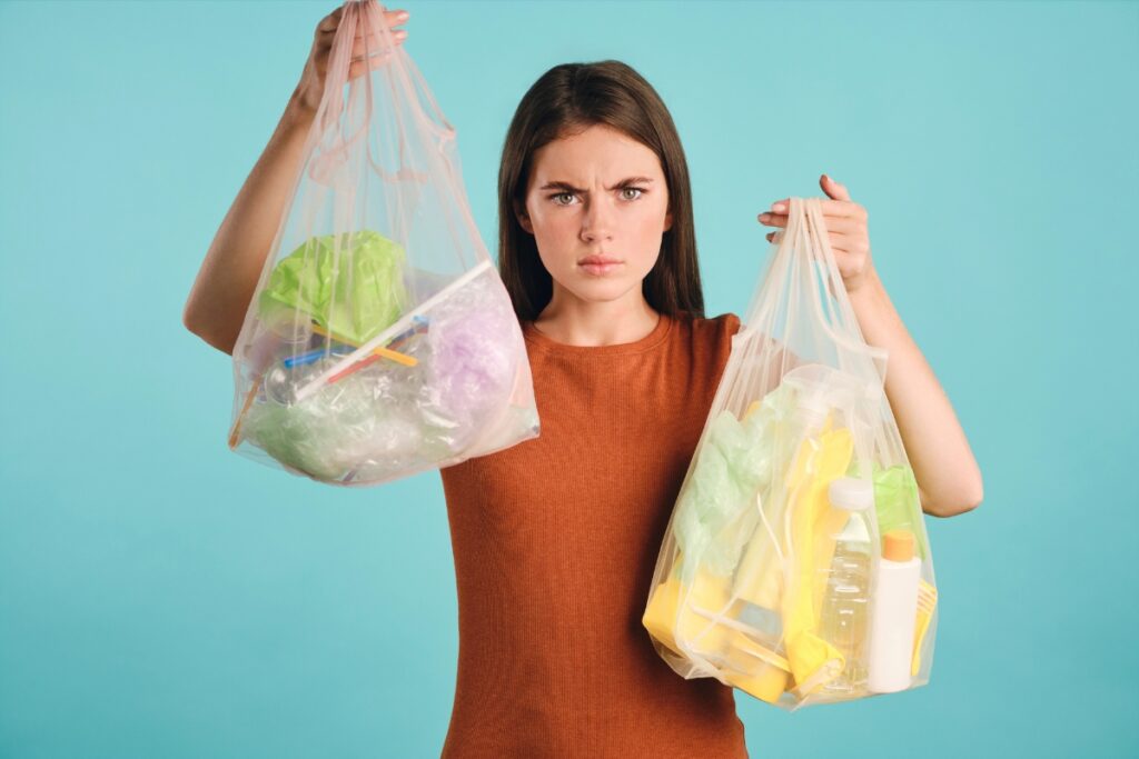 Woman holding groceries in excessive plastic packaging.
