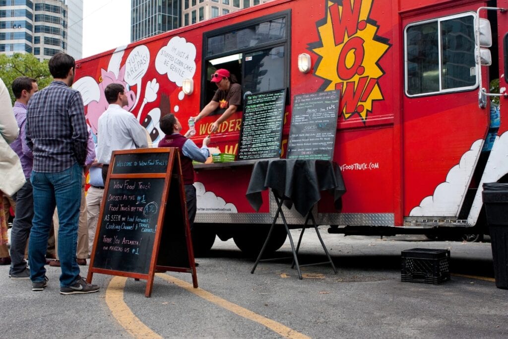 Street food truck serving customers outdoors.
