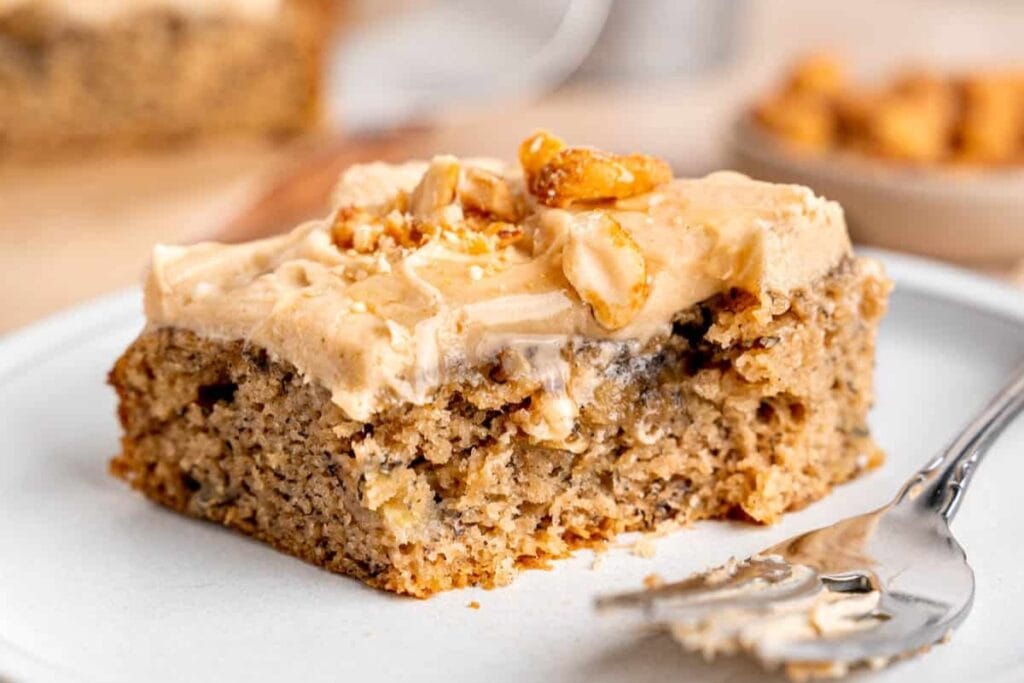Frosted banana snack cake on a plate.