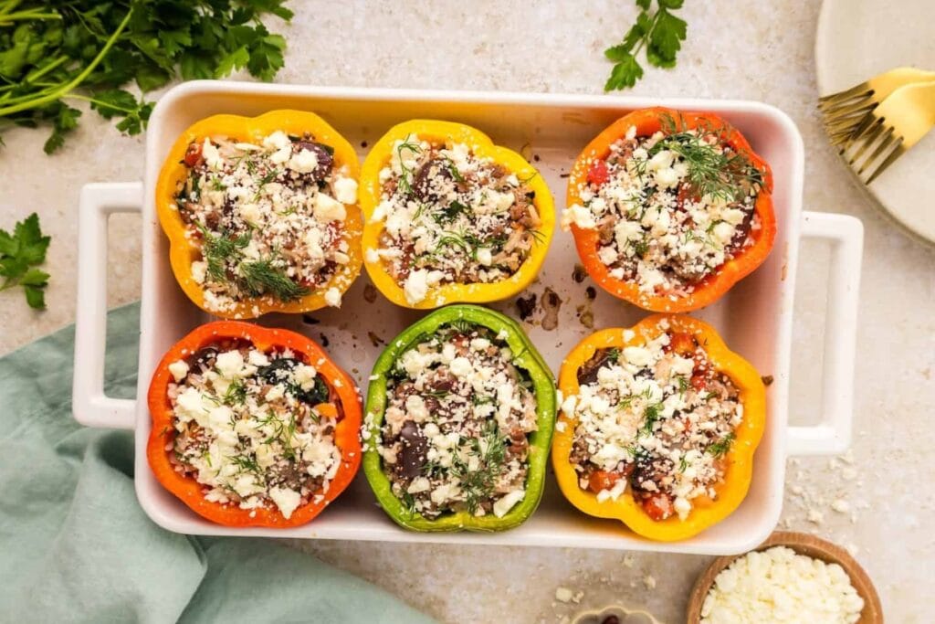 Greek stuffed peppers in a baking dish.