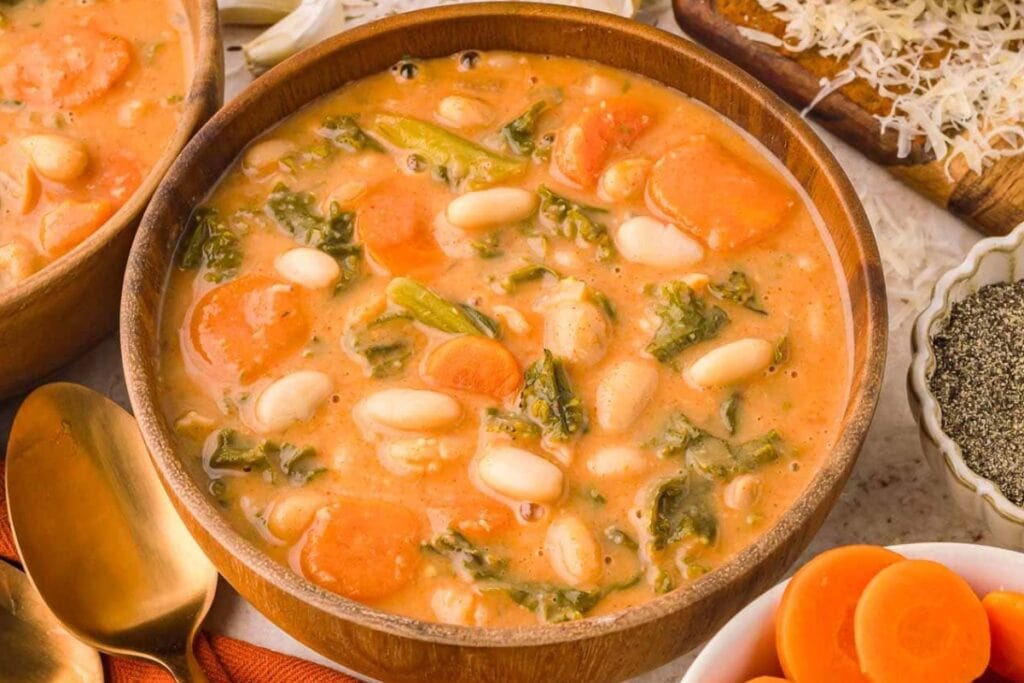 Kale and white bean soup in a wooden bowl.