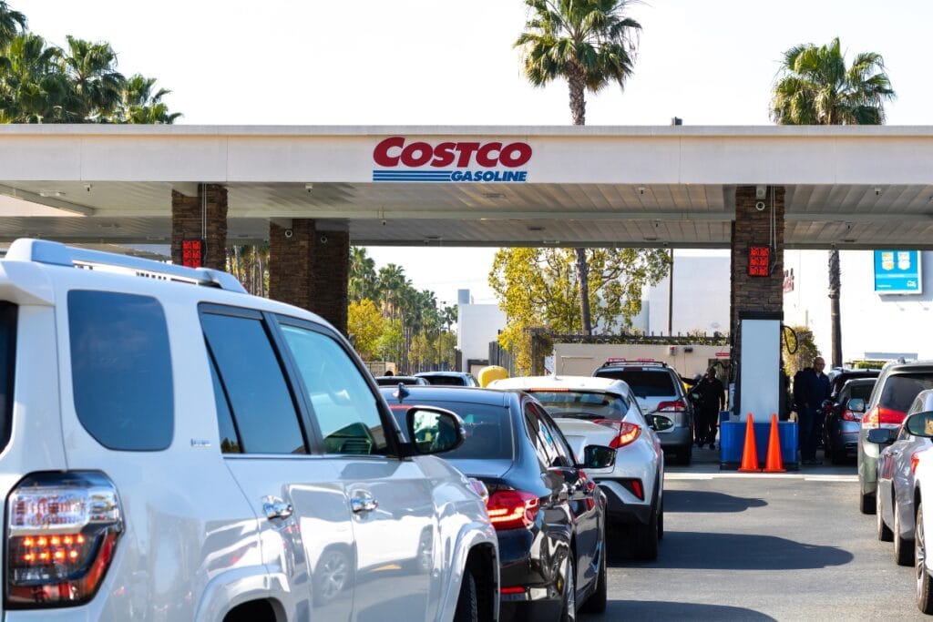 A long line of cars waiting at a gas station.